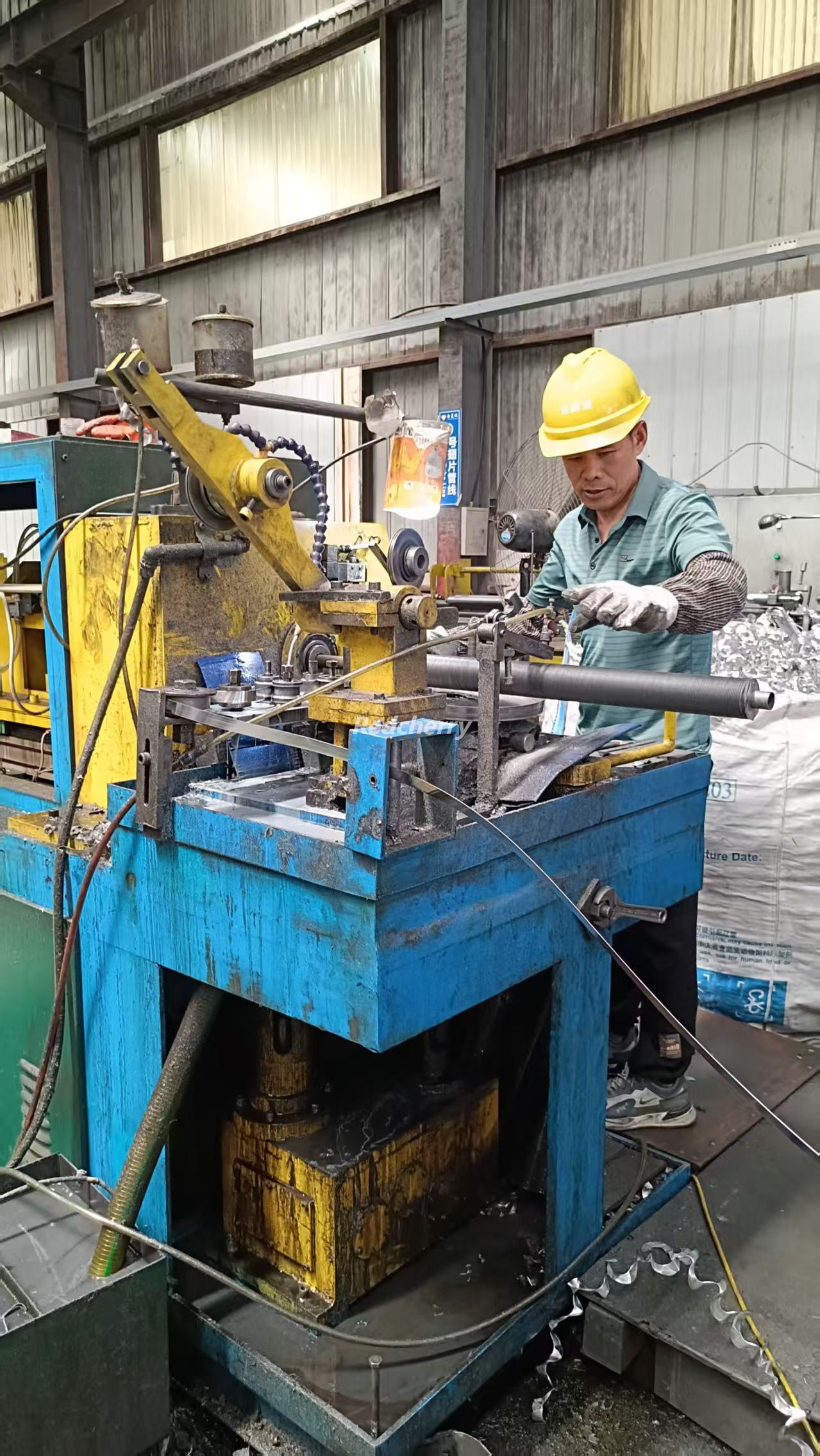 Technician ensuring strong fin-to-tube bonding on aluminum finned tubes for improved heat transfer efficiency.